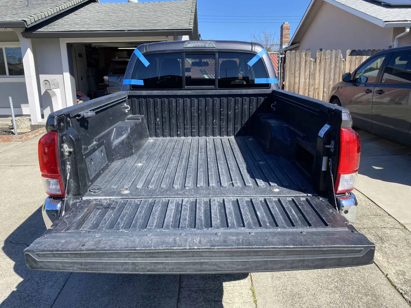 Rear window replacement on a truck in Roseville, CA — blue tape marks fresh install